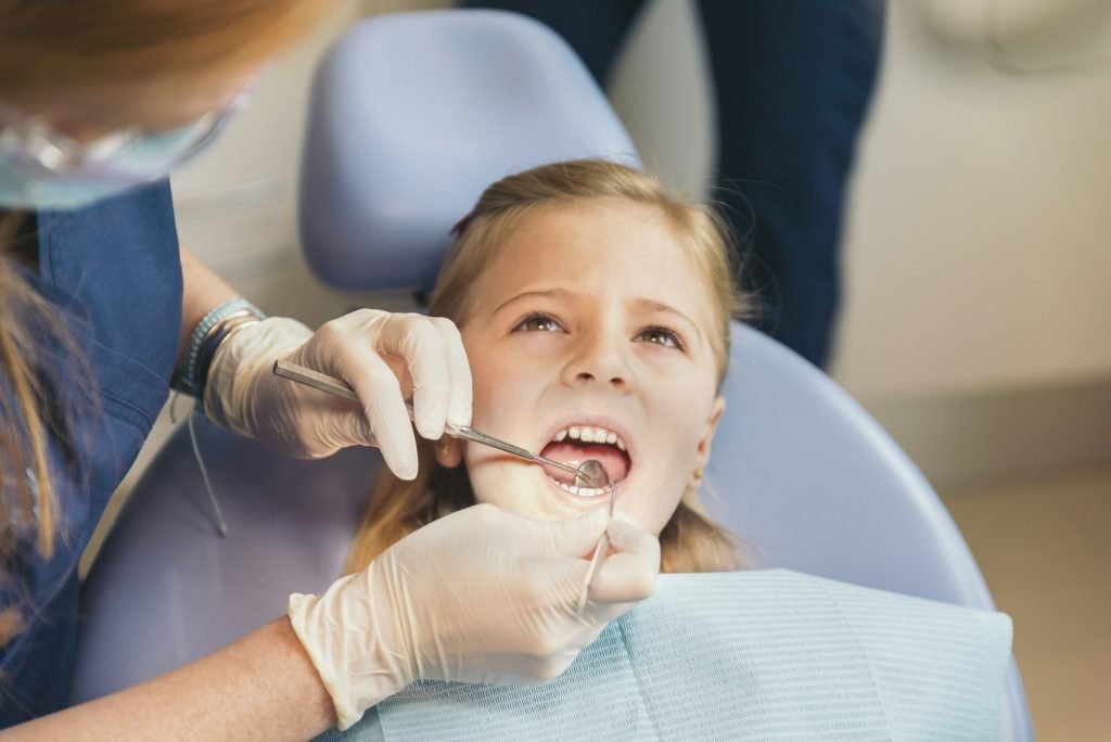 Dentists with a patient during a dental intervention to girl.